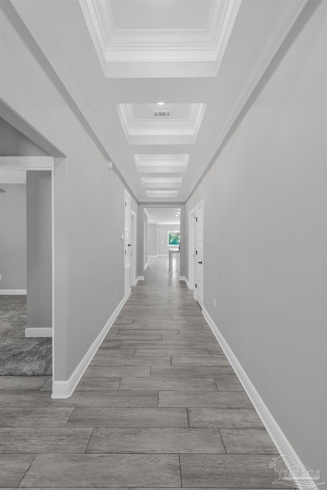 corridor featuring a tray ceiling, light hardwood / wood-style flooring, and ornamental molding