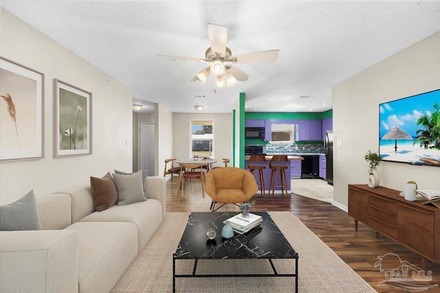 living room featuring a textured ceiling, ceiling fan, and hardwood / wood-style flooring