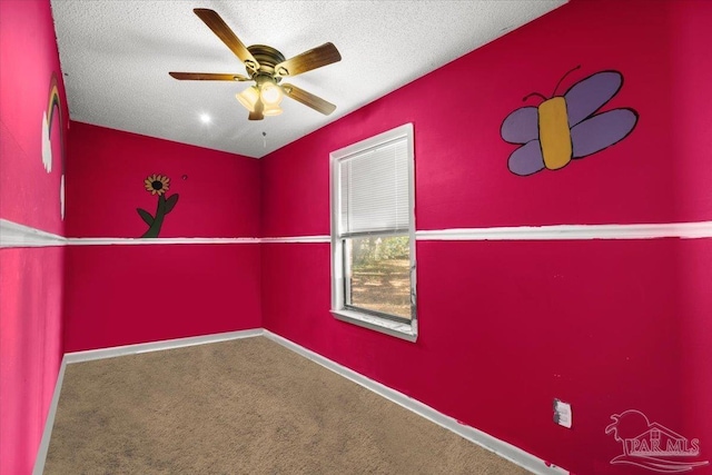 carpeted spare room with ceiling fan and a textured ceiling