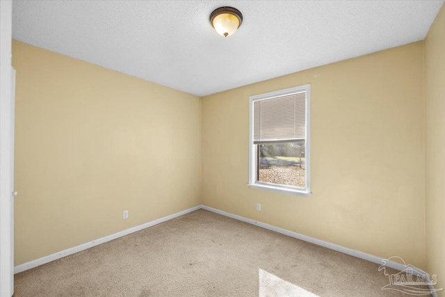 spare room with a textured ceiling and carpet floors