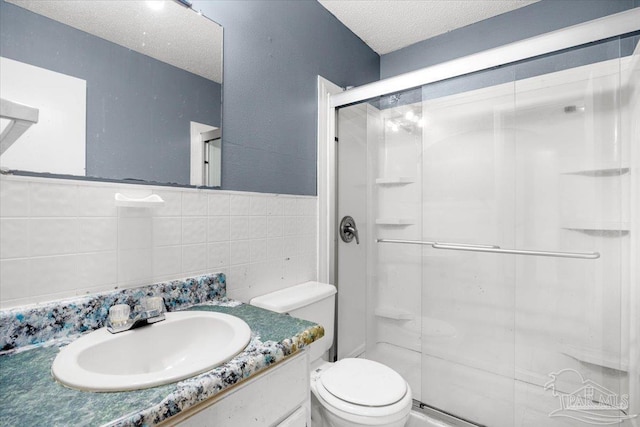 bathroom with tile walls, an enclosed shower, a textured ceiling, and toilet