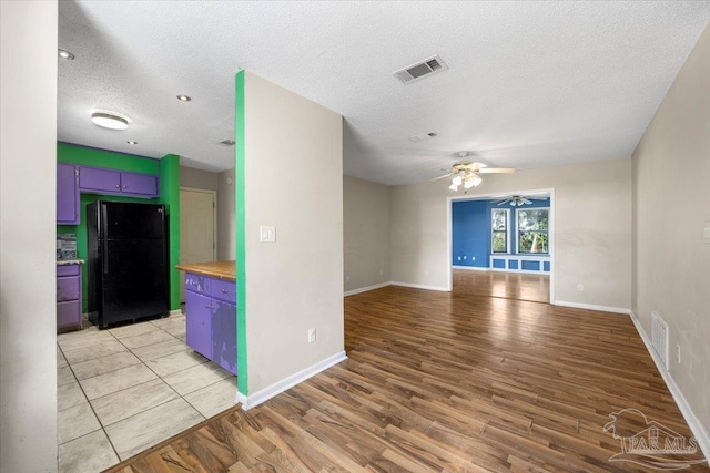 interior space with ceiling fan, light hardwood / wood-style flooring, and a textured ceiling