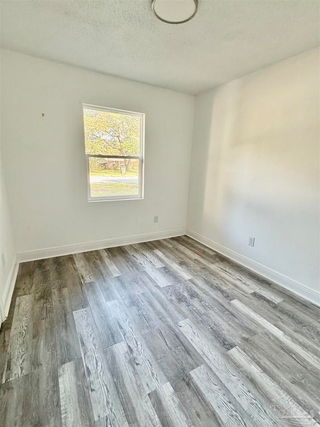 unfurnished room featuring a textured ceiling and light wood-type flooring