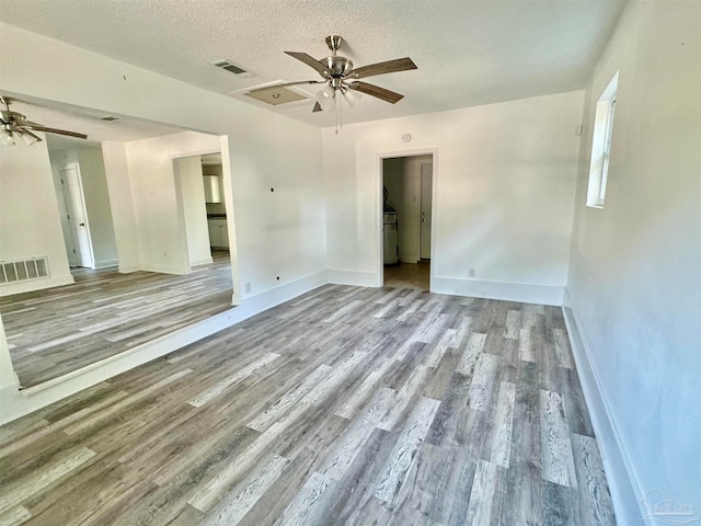 empty room with a textured ceiling and light hardwood / wood-style flooring