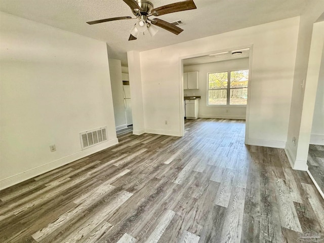 unfurnished room featuring a textured ceiling, wood-type flooring, and ceiling fan