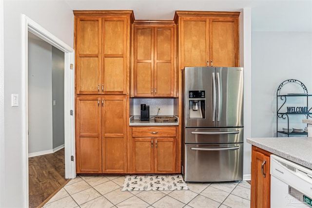 3640 Schifko Rd, Cantonment, FL 32533 - kitchen with stainless steel fridge, white dishwasher, light countertops, brown cabinets, and baseboards