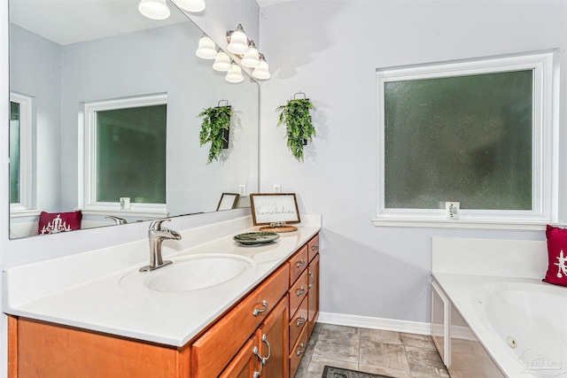 3640 Schifko Rd, Cantonment, FL 32533 - bathroom featuring a chandelier, vanity, a tub with jets, and baseboards