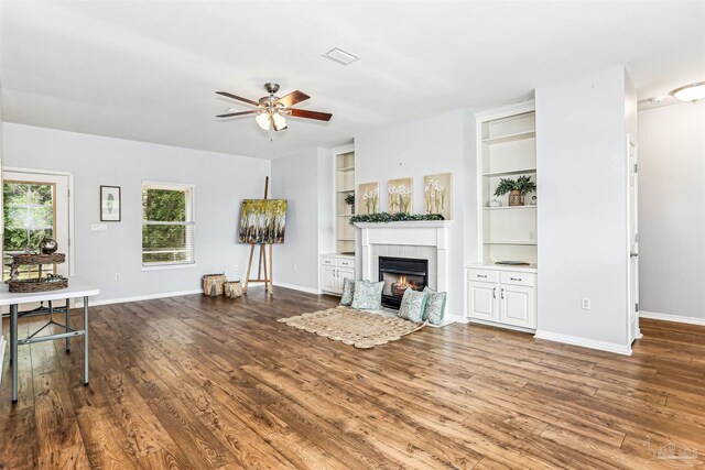3640 Schifko Rd, Cantonment, FL 32533 - living room featuring a ceiling fan, a tiled fireplace, wood finished floors, and baseboards