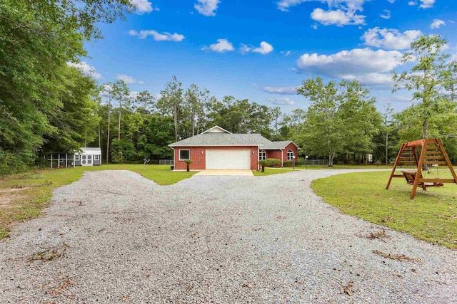 3640 Schifko Rd, Cantonment, FL 32533 - view of side of home featuring gravel driveway, an attached garage, a lawn, brick siding, and view of scattered trees