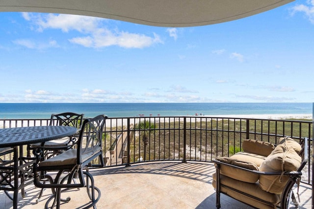 balcony with a water view and a view of the beach