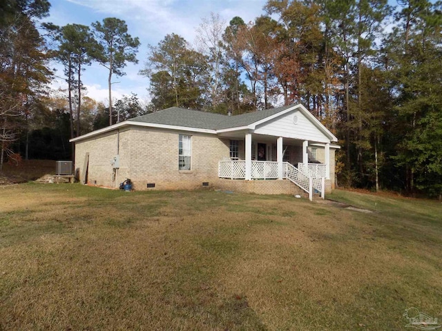 view of front facade with cooling unit, covered porch, and a front lawn