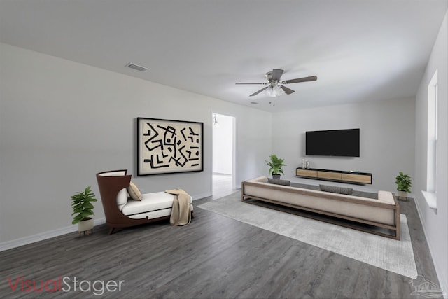 living area featuring dark wood-style floors, ceiling fan, visible vents, and baseboards