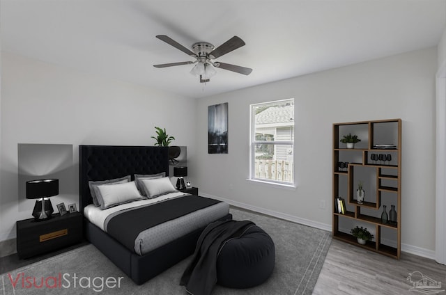 bedroom with light wood-type flooring, ceiling fan, and baseboards