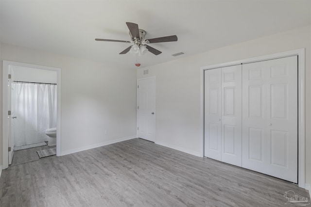 unfurnished bedroom featuring baseboards, a closet, visible vents, and light wood-style floors