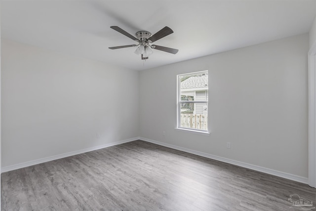 unfurnished room with a ceiling fan, baseboards, and wood finished floors