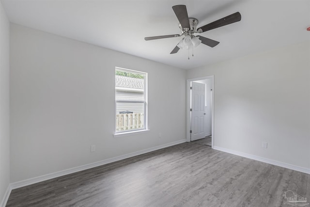 unfurnished room featuring a ceiling fan, baseboards, and wood finished floors