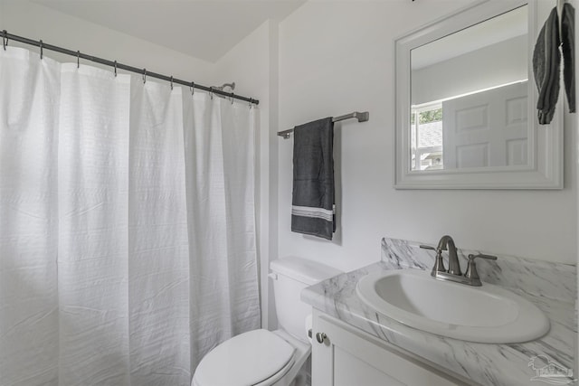 bathroom with toilet, curtained shower, and vanity