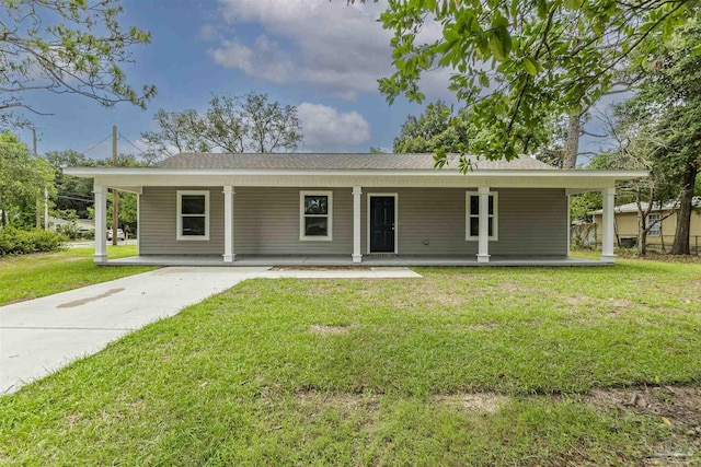 view of front of property with a carport, covered porch, a front lawn, and concrete driveway