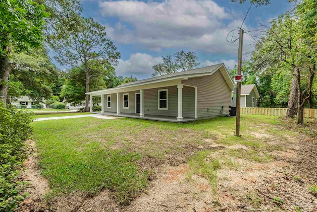 view of front of home featuring fence and a front lawn