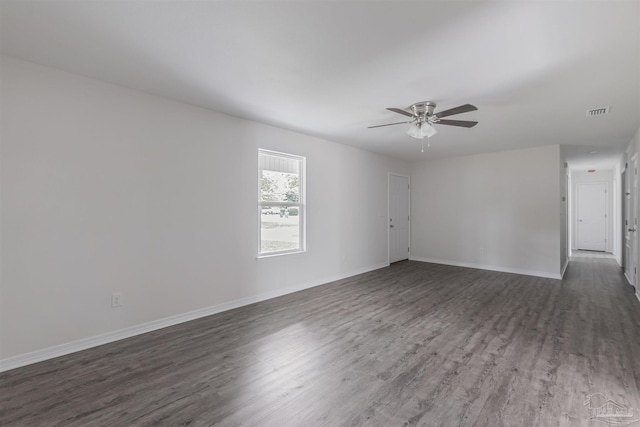 spare room with ceiling fan, baseboards, visible vents, and dark wood finished floors