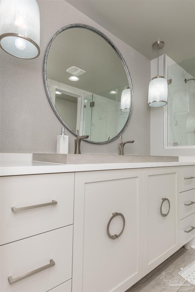 bathroom with a shower with door, vanity, and hardwood / wood-style flooring