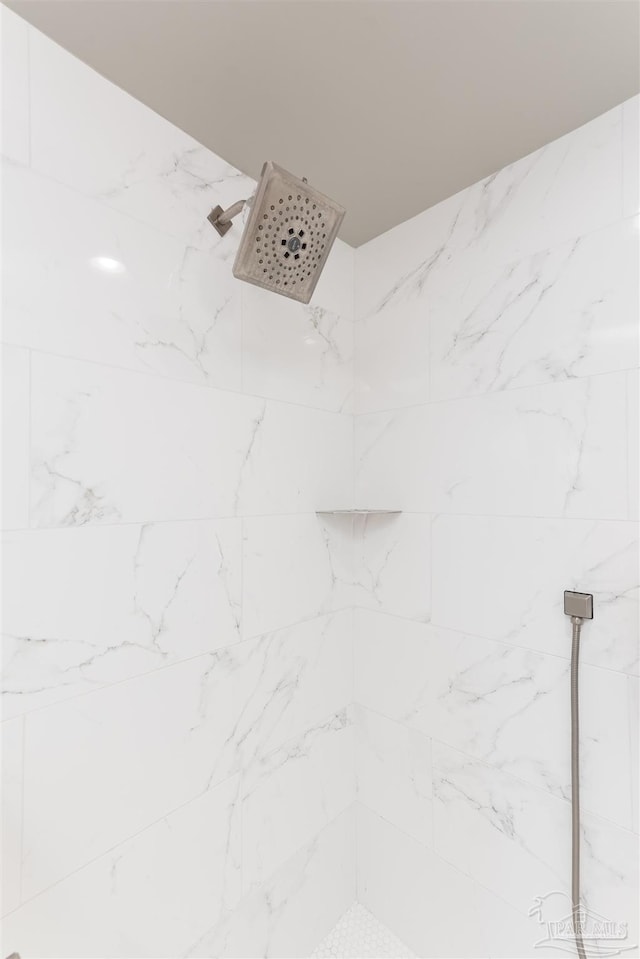 interior details with a tile shower