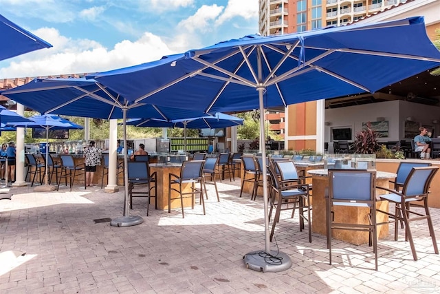 view of patio featuring outdoor dry bar and fence