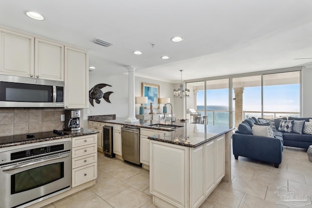 18 Via Deluna Dr Unit 603, Pensacola Beach, FL 32561 - kitchen featuring stainless steel appliances, wine cooler, decorative columns, decorative backsplash, and dark stone counters