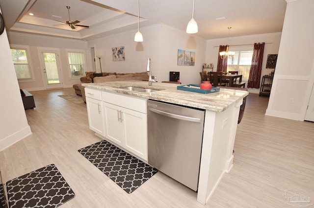 kitchen featuring stainless steel dishwasher, sink, a tray ceiling, white cabinetry, and hanging light fixtures