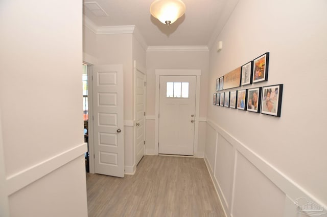 doorway to outside with ornamental molding and light wood-type flooring