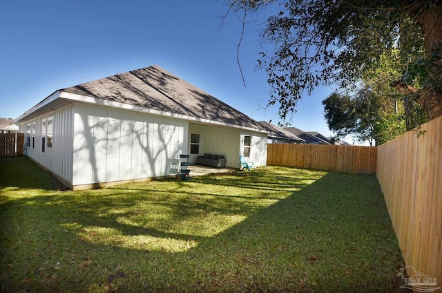 rear view of property featuring a yard and a patio