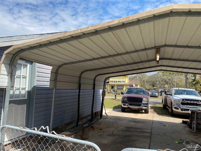 view of parking / parking lot with fence and a carport