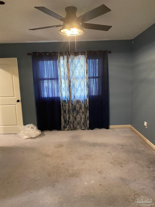 empty room featuring carpet, ceiling fan, and baseboards