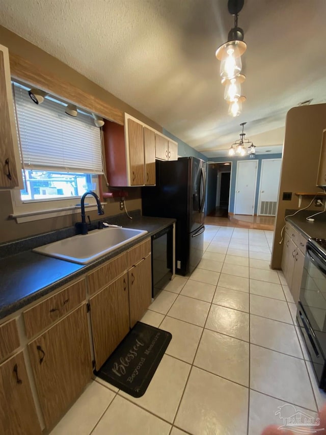 kitchen featuring dark countertops, lofted ceiling, black appliances, a sink, and light tile patterned flooring