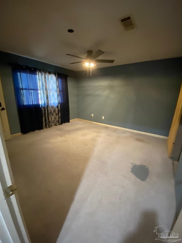 unfurnished room featuring ceiling fan, visible vents, and baseboards