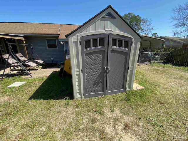 view of shed featuring fence and a detached carport