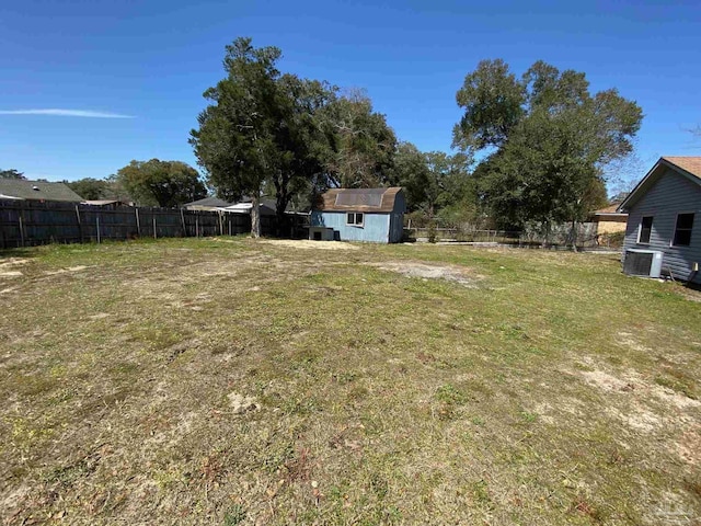 view of yard featuring an outbuilding, a storage unit, and a fenced backyard