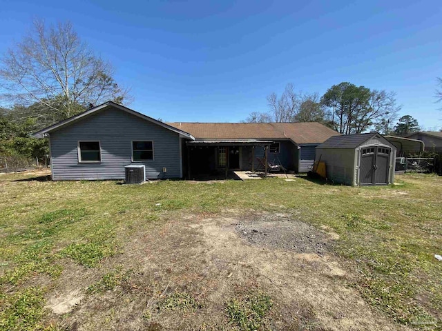 rear view of house with cooling unit, an outdoor structure, a storage shed, and a lawn