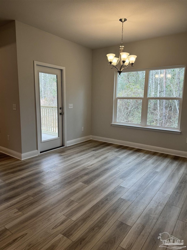 empty room featuring dark hardwood / wood-style flooring and a notable chandelier