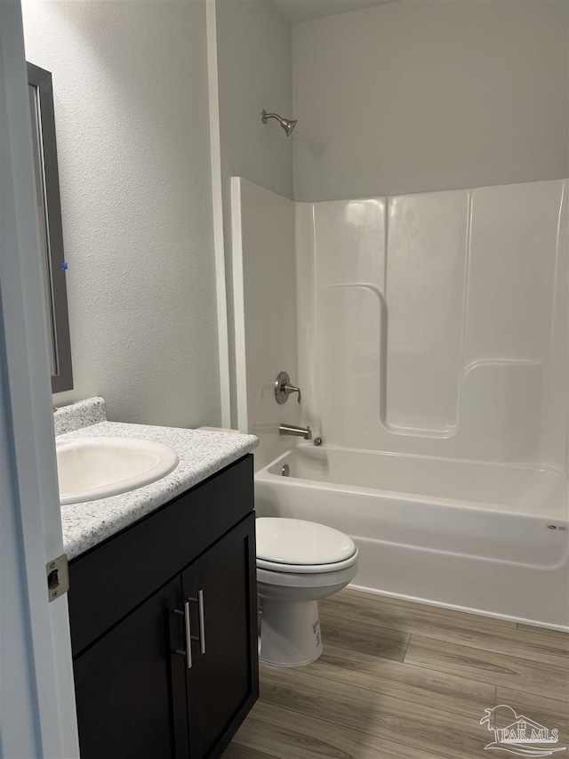 full bathroom with hardwood / wood-style flooring, vanity, toilet, and shower / bathing tub combination