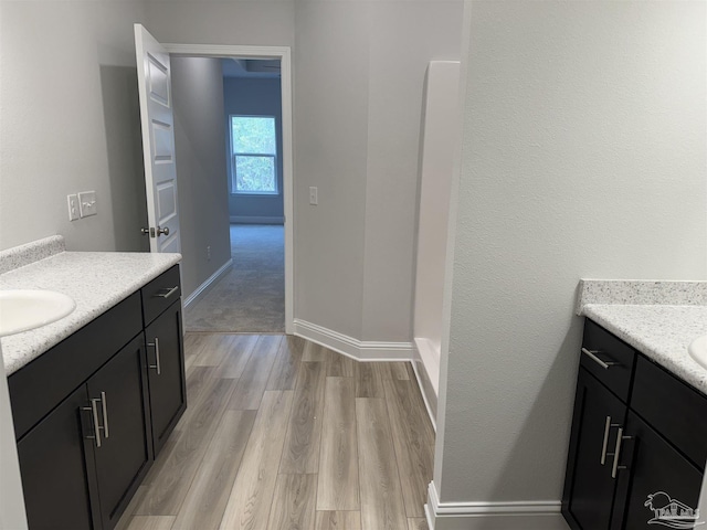 bathroom featuring hardwood / wood-style flooring, vanity, and a shower