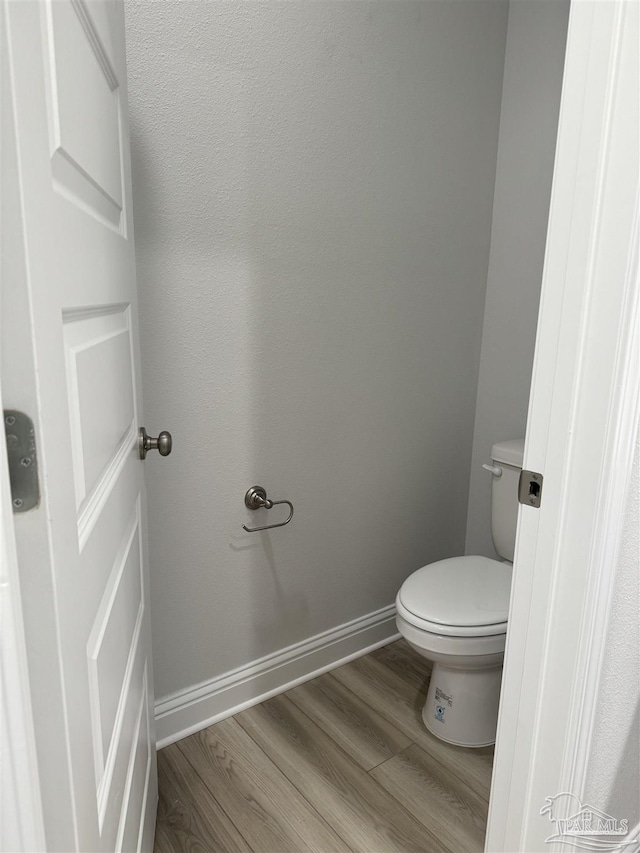 bathroom with hardwood / wood-style flooring and toilet