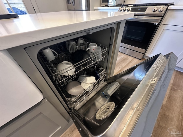 interior details with appliances with stainless steel finishes and hardwood / wood-style floors