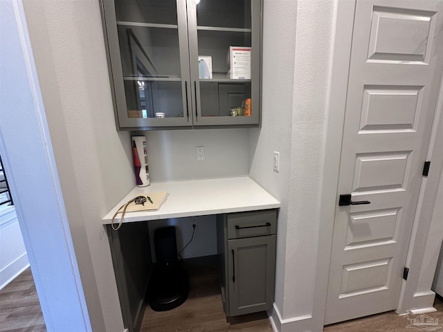 office featuring dark hardwood / wood-style flooring and built in desk