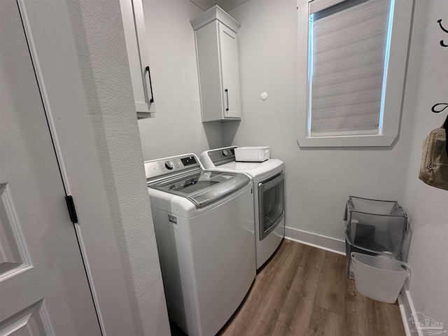 laundry room with cabinets, dark hardwood / wood-style flooring, and independent washer and dryer