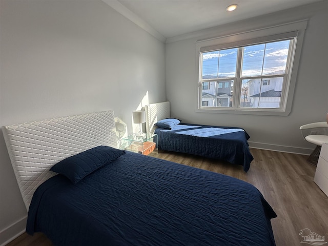 bedroom featuring lofted ceiling, ornamental molding, and hardwood / wood-style floors