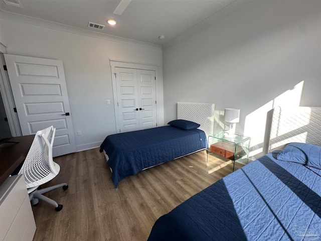 bedroom featuring dark hardwood / wood-style floors, a closet, and ornamental molding