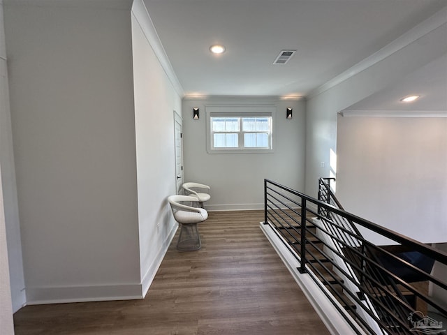 staircase with wood-type flooring and crown molding