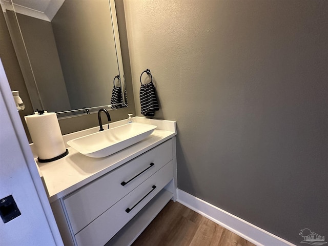 bathroom featuring vanity, crown molding, and hardwood / wood-style flooring