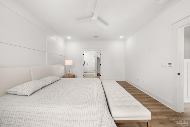 bedroom featuring ceiling fan, ornamental molding, and hardwood / wood-style floors